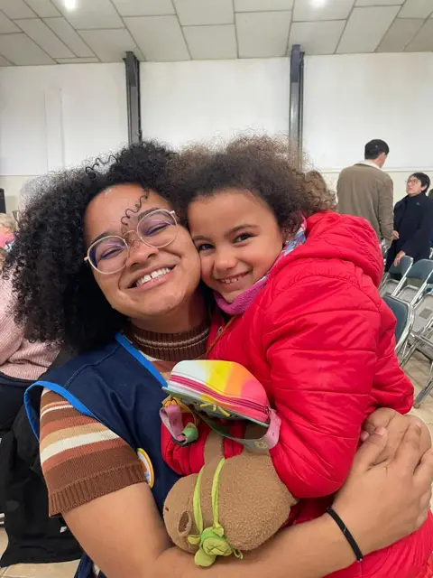 Una mamá con su hija en brazos